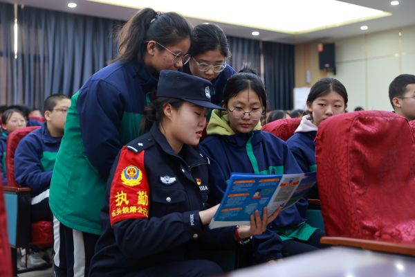 03031740989443268926.jpg 民警向学生讲解安全手册.JPG