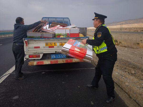 新和执法大队执法人员帮助驾驶员将货物整理装车，重新捆扎牢固1.jpg