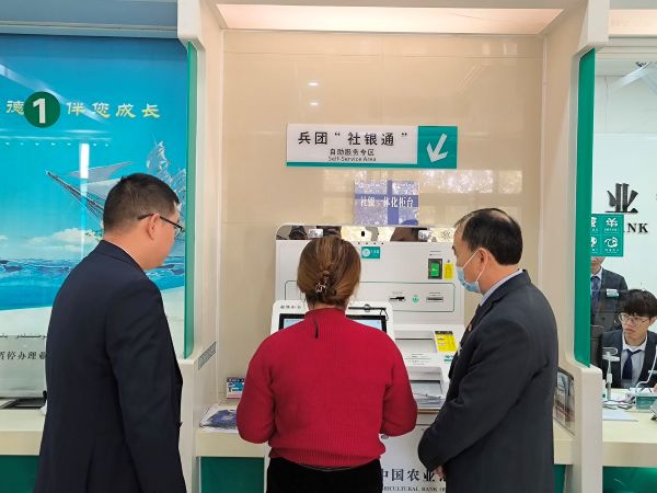 银行人员和社保人员指导办事群体通过一体机进行养老认证.jpg