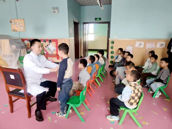 图为：胡坚为幼儿听诊。 黄叶叶 摄.jpg