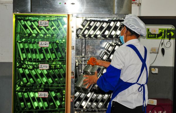 04301746017526765452.jpg 图为杨胜祝在将清洗的碗具放到消毒柜进行消毒。.jpg