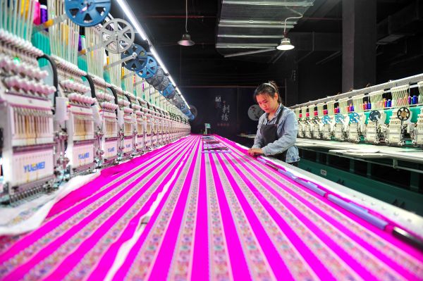 2025年5月8日，在贵州省从江县一家民族刺绣企业生产车间，工人在用数控机床生产刺绣产品 (3).jpg