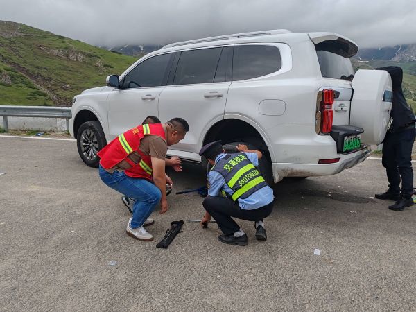 图2 执法人员在白石峰帮助游客救援故障车辆.jpg