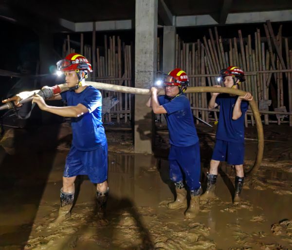 图为  消防指战员在停洞镇冲洗淤泥现场（欧蓉蓉  摄）.jpg