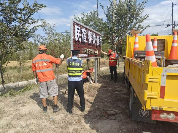 08211755772783991108.jpg 图片1:执法人员联合养护人员对公路控制区内摆放的广告牌进行清理.jpg