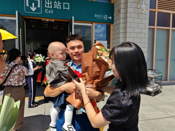 图为 丙妹镇尧等村退役军人贾金强的妻子和小孩在高铁站迎接现场（卢月圆 摄）.jpg