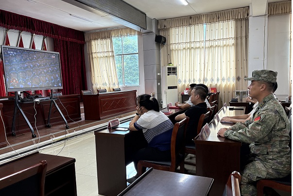 图为 下江镇党委委员、人武部长（退役军人）石春远观看大阅兵现场（龙石兰 摄）.jpg