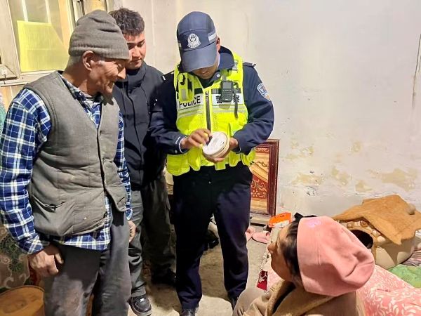民警正在向老人讲解一氧化碳报警器的使用方法，手把手演示设备测试步骤，老人专注聆听，现场交流氛围亲切。.jpg