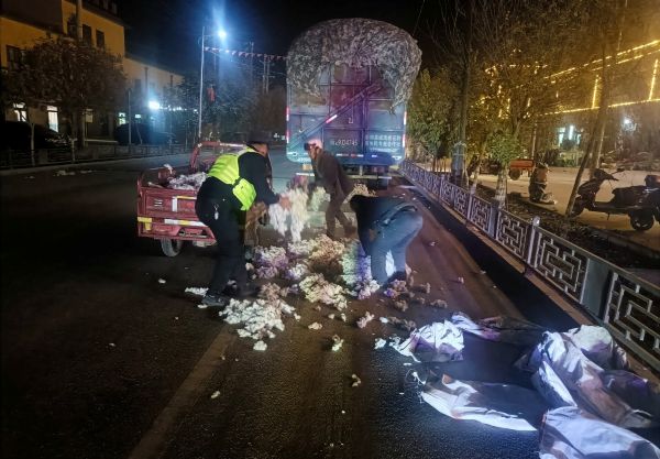 民警帮助司机师傅一同捡起掉落的棉花.jpg