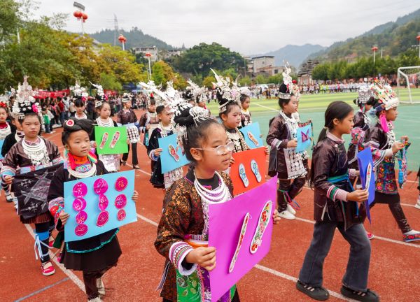 2025年11月6日，学生在贵州省黔东南苗族侗族自治州从江县城关第四小学的足球联赛开幕式上展示刺绣工艺品。 (2).jpg