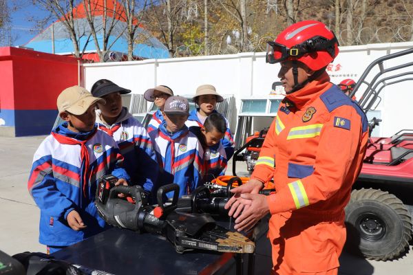 消防员讲解救援装备用途，学生们好奇围观，近距离了解救援知识。.JPG