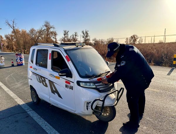 民警认真将反光条贴在车辆前侧醒目位置。车身的“警”字标识，也让这场便民服务多了份安心底色，小小的反光条让村民日常出行的代步工具，在夜色里多了层安全保障.jpg