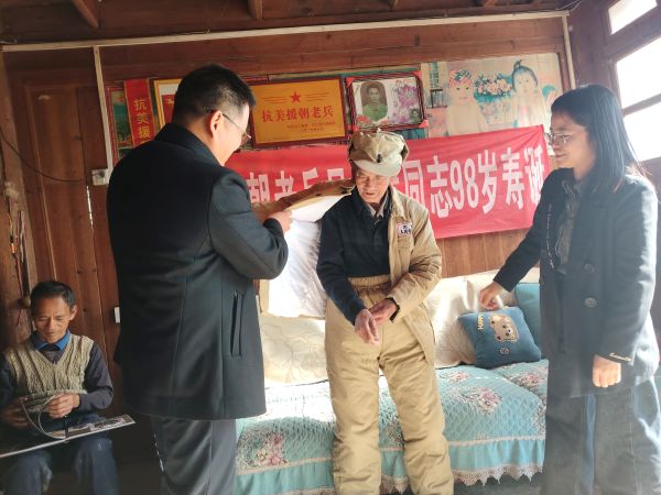 图为 慰问组在洛香镇帮助老兵更换衣服现场（韦绍东 摄）.jpg