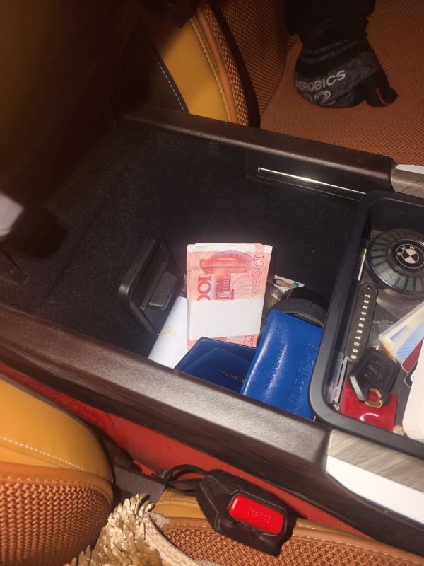 车内扶手箱里，1万元现金与证件等物品随意放置。敬浩龙摄.jpg