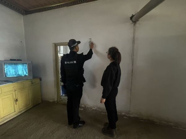 12221766398892417994.jpg 民警在群众家中检查烟感报警器的运行状态,一边调试设备,一边向身旁群众讲解报警器的作用与日常维护要点。敬浩龙摄.jpg